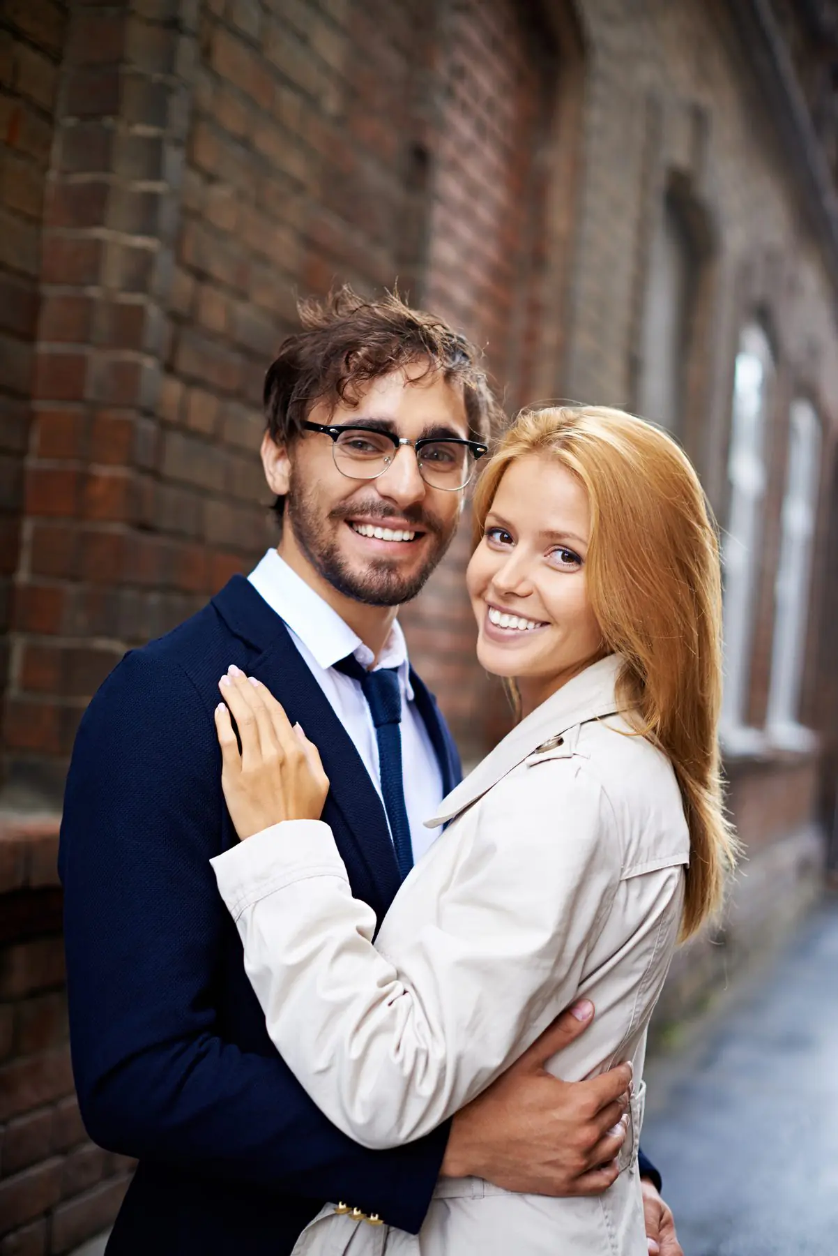 A well-dressed professional couple smiling together